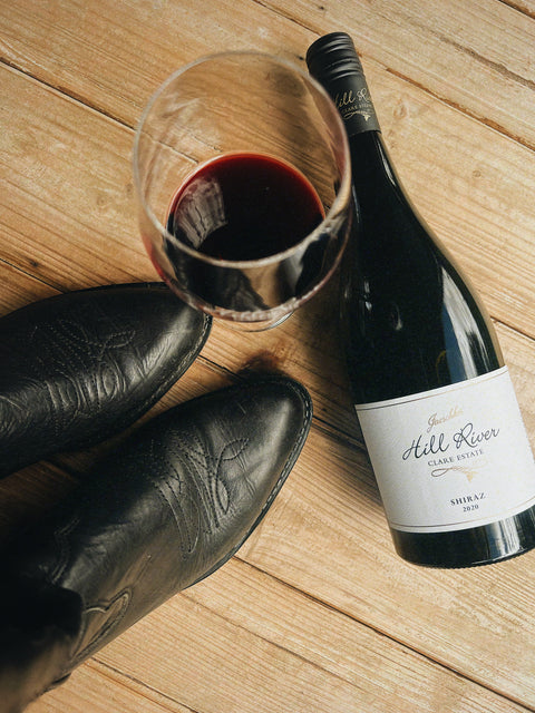 Hoedown over the Hill. Image of black cowboy boots, a glass and a bottle of Hill River Wines Shiraz